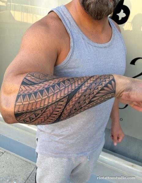Polynesian tribal half sleeve tattoo with geometric patterns on upper arm and forearm
