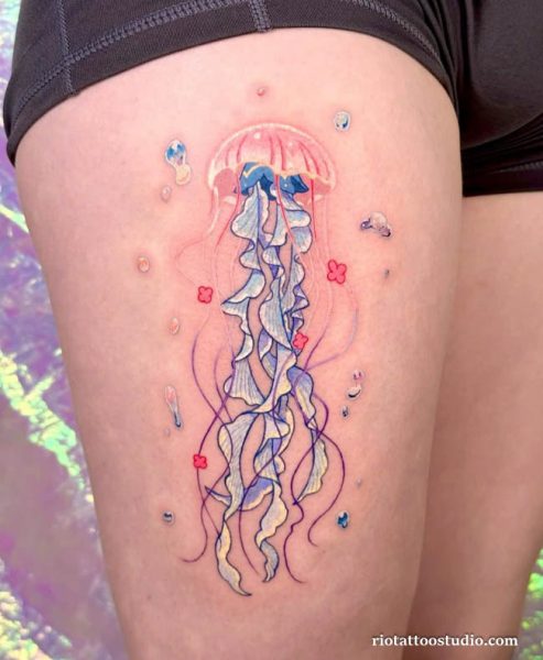 Vibrant colorful jellyfish tattoo with blue, pink and yellow tones, bubbles and flowers on thigh, jellyfish tattoo ideas