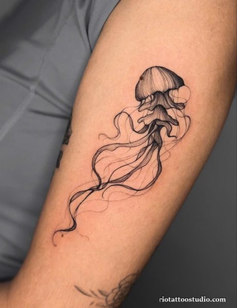 Elegant fine line black jellyfish tattoo with long flowing tentacles on upper arm, jellyfish tattoo ideas