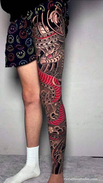 Japanese snake leg sleeve tattoo with red accents and cherry blossoms on full leg, traditional leg sleeve tattoo ideas