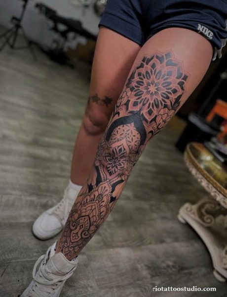 Mandala and floral leg sleeve tattoo in black and red on thigh and calf, geometric leg sleeve tattoo ideas