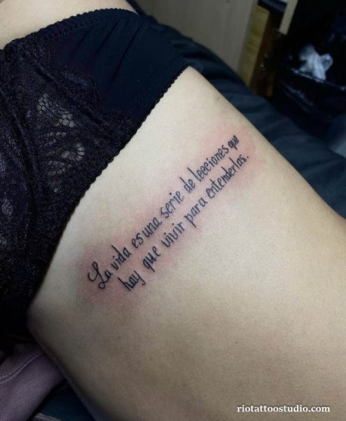 Spanish quote script rib tattoo “La vida es una serie de lecciones que hay que vivir para entenderlas” on woman’s side, meaningful rib tattoo ideas