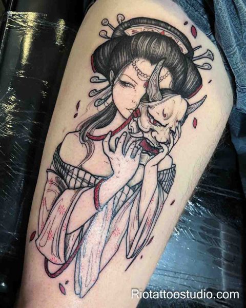 Japanese geisha holding Hannya mask thigh tattoo with red accents on upper thigh, thigh tattoo ideas