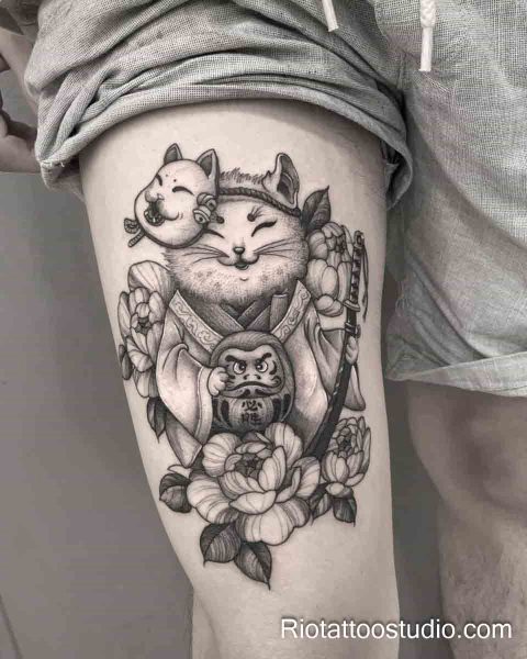 Lucky Maneki-neko cat with Daruma doll and peonies thigh tattoo in black and grey, thigh tattoo ideas