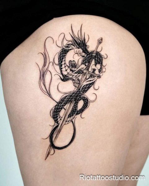 Japanese dragon coiled around sword thigh tattoo in black and grey on upper thigh, thigh tattoo ideas
