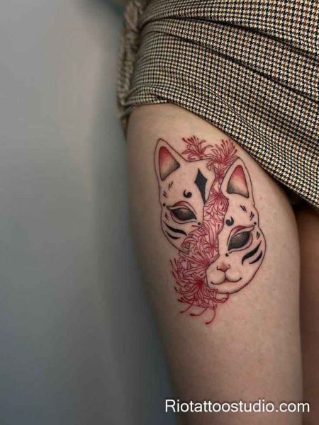 Japanese Hannya mask thigh tattoo with red spider lilies in black and red on upper thigh, thigh tattoo ideas