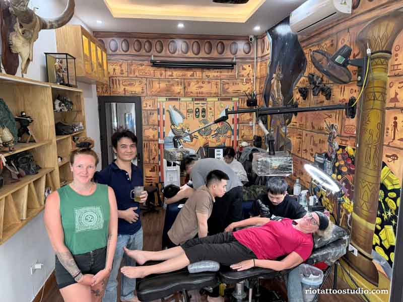 Professional artist tattooing a custom clock tattoo for a foreign client at Rio Studio