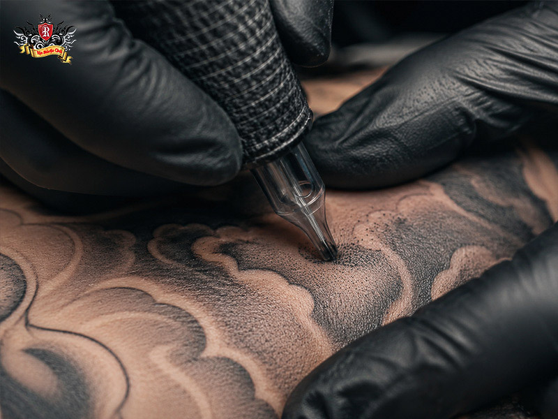 Professional artist doing detailed shading for cloud tattoo.