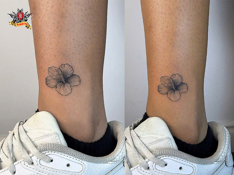 Elegant fine-line mini hibiscus tattoo on wrist or ankle.
