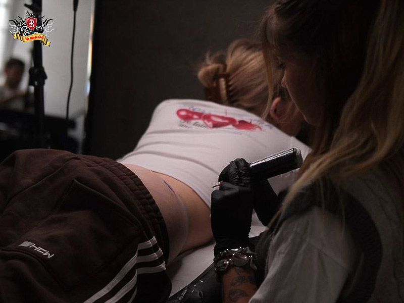 Professional artist creating a delicate tattoo hip design.