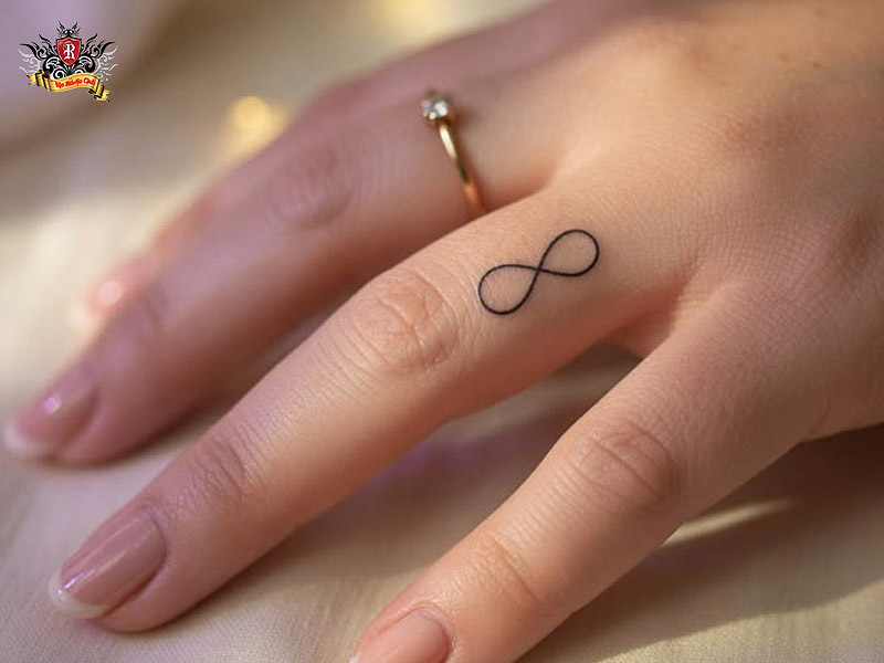 Minimalist infinity tattoo on finger and wrist.