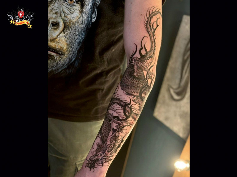 Dynamic Chinese dragon tattoo wrapping seamlessly around the arm as a sleeve with a coiled tail at Rio Tattoo Studio.